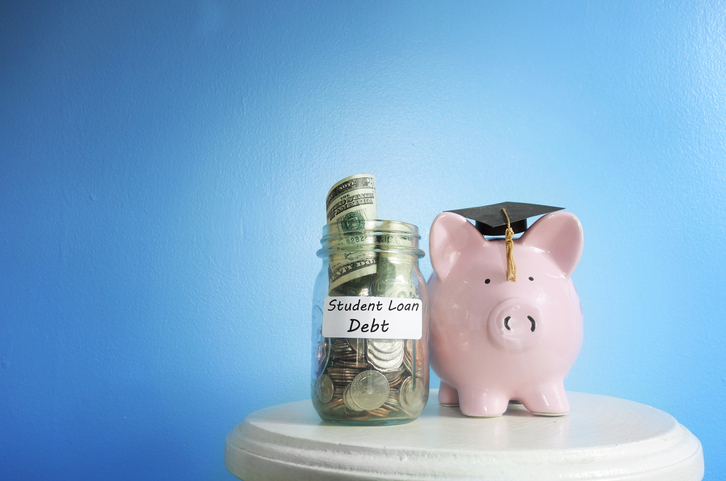  Piggy bank with graduation cap beside a student loan coin jar